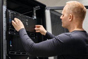 male-technician-installing-servers-in-enterprise-datacenter-for-cloud-hosting